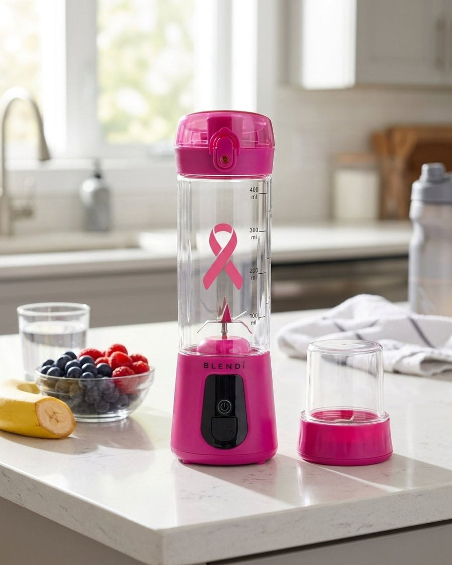 Hot Pink BLENDi Pro+ Breast Cancer Awareness Edition on a kitchen counter with fresh berries